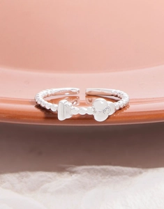 Macro view of silver S925 beaded ring with flower charm and sparkling zircon detail
