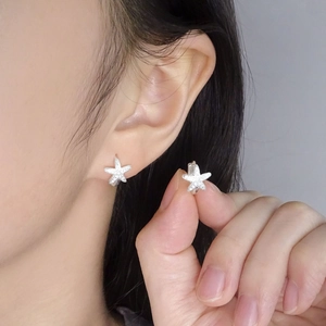 Sparkling S925 sterling silver starfish hoop earrings with zircon stones worn by a model