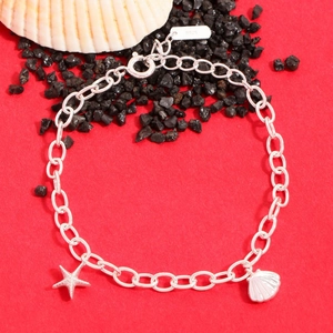 Minimalist S925 sterling silver bracelet with starfish and seashell charms on red background
