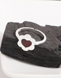 Dettaglio dell'anello in argento S925 con motivo floreale a cuore rosso su carbone scuro
