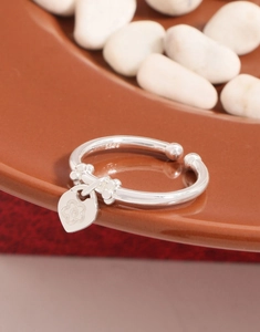 Close-up of S925 sterling silver ring with heart charm and engraved flower detail