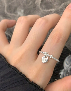 Close-up of S925 sterling silver ring with floral heart charm and bead details on finger