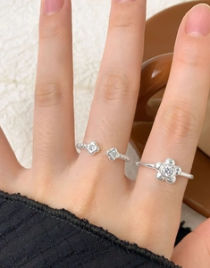 Detailaufnahme von silbernen S925 Blumenringen mit Zirkonia, am Finger getragen