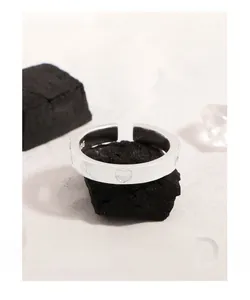 Vue macro de la bague en argent S925 montrant le nœud gravé, le cœur et le poinçon