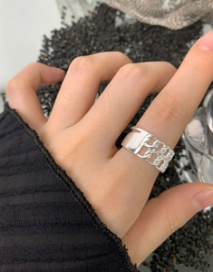 Macro shot of S925 sterling silver hollow chain ring worn on a finger for fashion details
