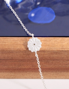 Macro detail of S925 sterling silver stamp on the back of a daisy flower pendant