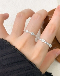 Macro shot of S925 sterling silver beaded rings with heart charms on a female hand