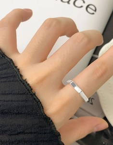 Close-up of polished S925 sterling silver geometric ring on finger with glossy finish