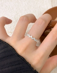 Detail of S925 sterling silver ring with interlocking pavé zircon crystals on finger