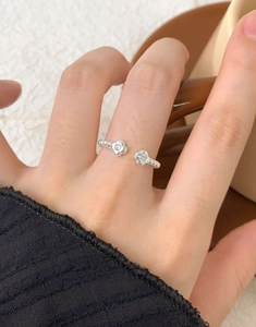 Detailansicht eines S925 Sterlingsilber Blumenrings mit Zirkonia am Finger eines Models
