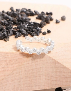 Detail of silver adjustable ring with continuous circular settings and sparkling zircons