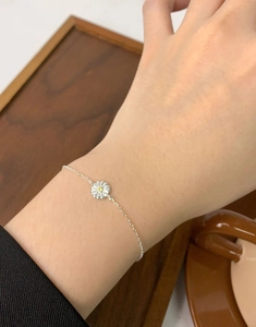 Close-up of S925 sterling silver daisy bracelet with yellow zircon on a female wrist