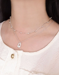 Gros plan d'un collier double rang en argent S925 avec pendentif cadenas en cœur