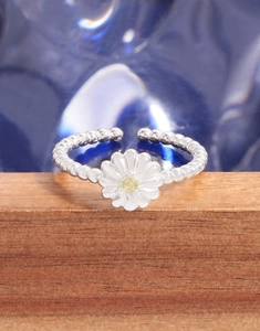 Macro detail of S925 silver beaded ring with white daisy flower and yellow gemstone