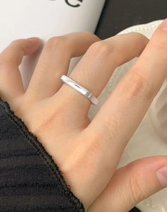 Detailed close-up of a minimalist silver geometric rectangular ring on a finger