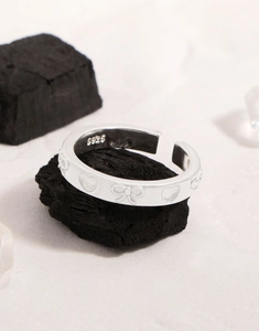 Macro de la bague en argent S925 montrant les détails gravés de cœur et de nœud