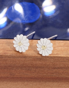 Detail of S925 silver daisy earrings featuring white enamel petals and yellow zircon centers