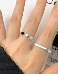 Detail of silver adjustable open ring with a black sphere and teardrop mirror finish