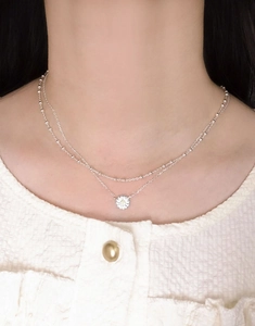 Dettaglio collana a doppio strato in argento S925 con pendente margherita e zirconi