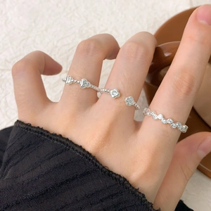 S925 sterling silver zircon flower and heart rings set shown on hand with ceramic cup