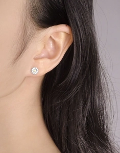 Close-up of elegant S925 sterling silver daisy earrings with white petals and yellow zircon