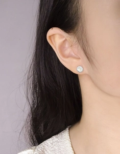 Detail showing elegant daisy stud earrings with yellow center and silver petals on a model
