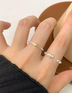 Detail of S925 sterling silver star rings with gold accents on model's fingers