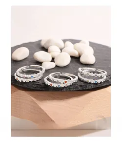 Macro detail of S925 sterling silver heart rings with colorful zircon on black stone