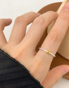 Close-up of a minimalist S925 silver star ring on a finger with a small gold star detail