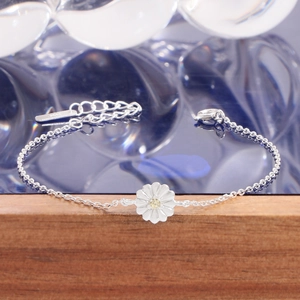 S925 sterling silver daisy bracelet with white petals and yellow zircon on blue background