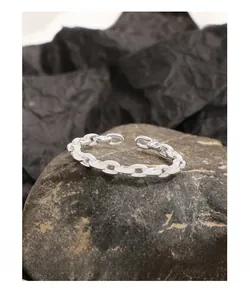 Macro shot of S925 sterling silver chain ring with industrial textured links on black stone