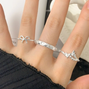Ensemble de trois bagues en argent S925 avec nœuds et cœurs portées à la main