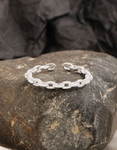 Detailed macro shot of S925 sterling silver chain link ring on natural stone background