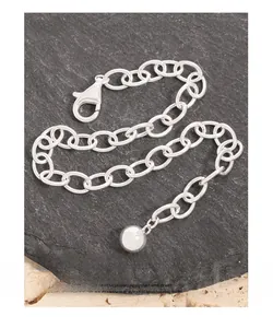 Détail d'un bracelet en chaîne argentée aux maillons ovales sur une ardoise noire