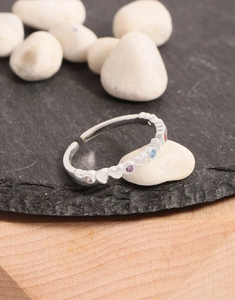 Macro detail of S925 silver rainbow zircon heart ring on zen white stones