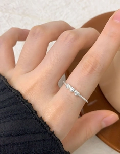 Close-up of S925 sterling silver ring with three heart-shaped zircons on a woman's finger