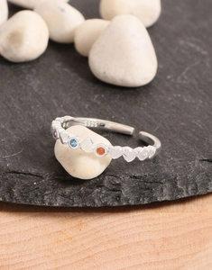 Detailed shot of S925 sterling silver ring with colorful zircons on a dark stone