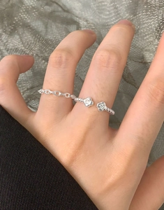Detail of S925 sterling silver chain ring with a zircon clover flower on a finger