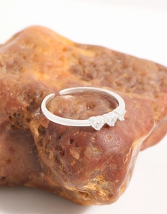 Detailed shot of S925 silver ring featuring three heart-shaped zircons on textured stone