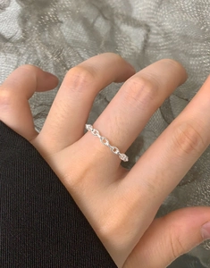 Minimalist S925 sterling silver thin chain ring shown on model's finger with a mesh background