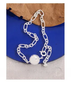 Macro shot of S925 sterling silver ball pendant and textured link chain on blue stand
