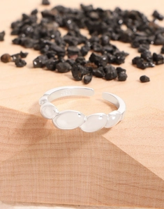 Makro-Detail von S925 Sterling Silber Ring mit glattem Kiesel-Muster auf Holzoberfläche