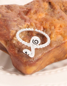 Macro detail of S925 sterling silver beaded ring with engraved spiral and star motifs