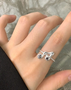 Detail of S925 sterling silver music note ring with twisted band and star engraving