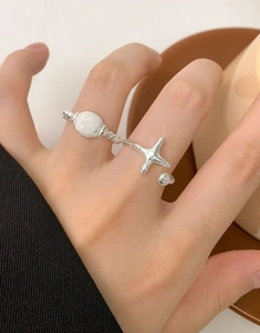 Detail of S925 sterling silver twisted rope ring with frosted star and bead charms