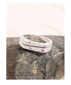 Macro detail of S925 sterling silver ring featuring pink zircons on black stone base