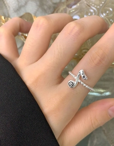 Detailed close-up of S925 sterling silver music note ring with black star accents