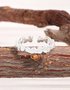 Macro view of S925 sterling silver adjustable ring with continuous heart design on wood