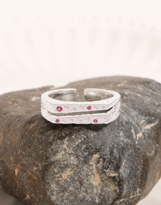 Macro detail of S925 silver ring with hand-hammered texture and pink zircon stones