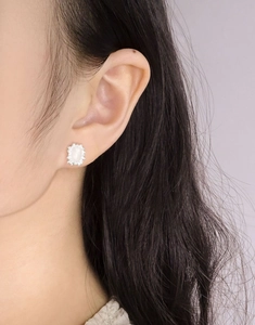 Close-up of S925 silver stud earrings with geometric pink crystal on a female model